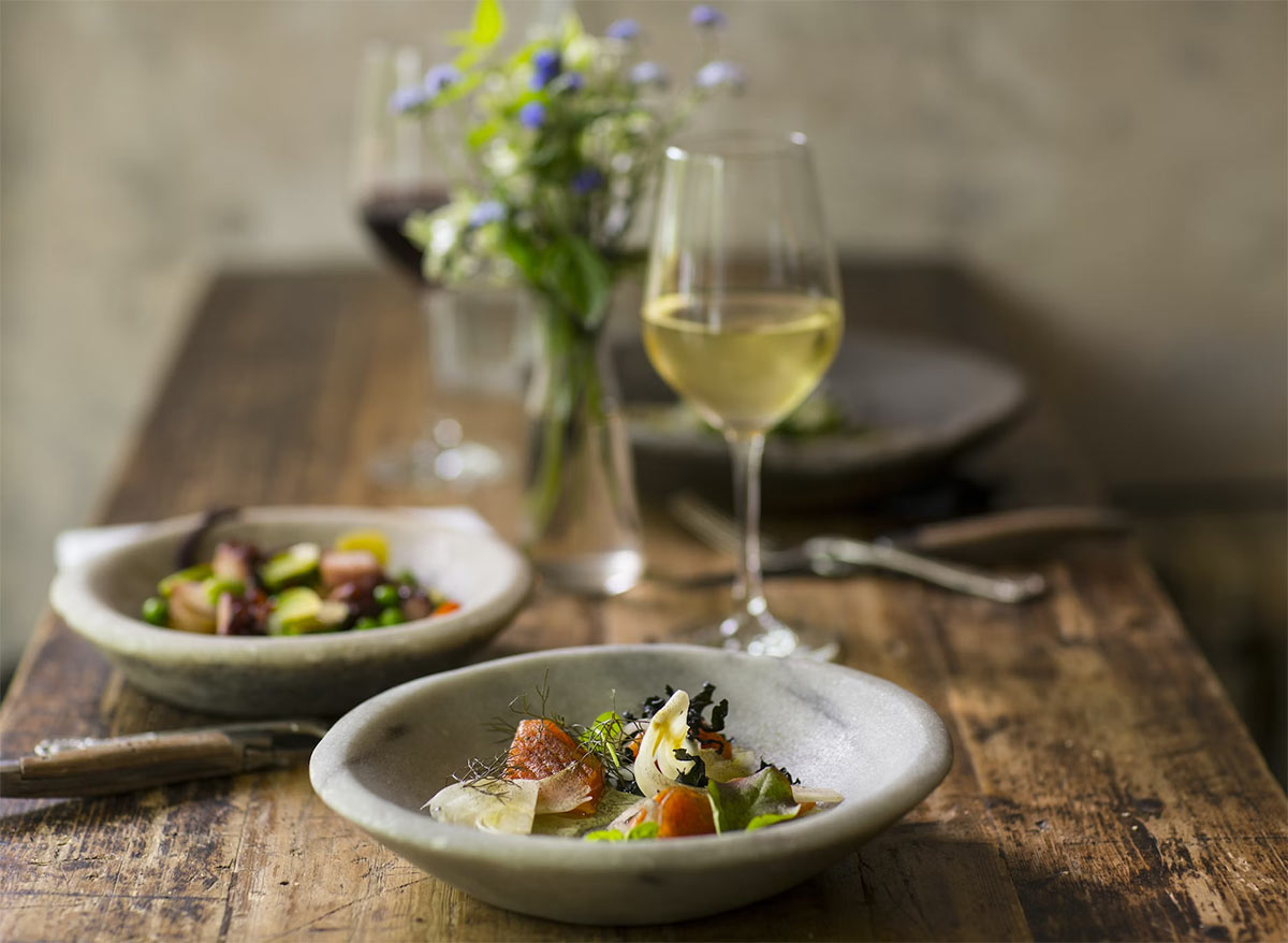 Mesa con comida y copas de distintos vinos